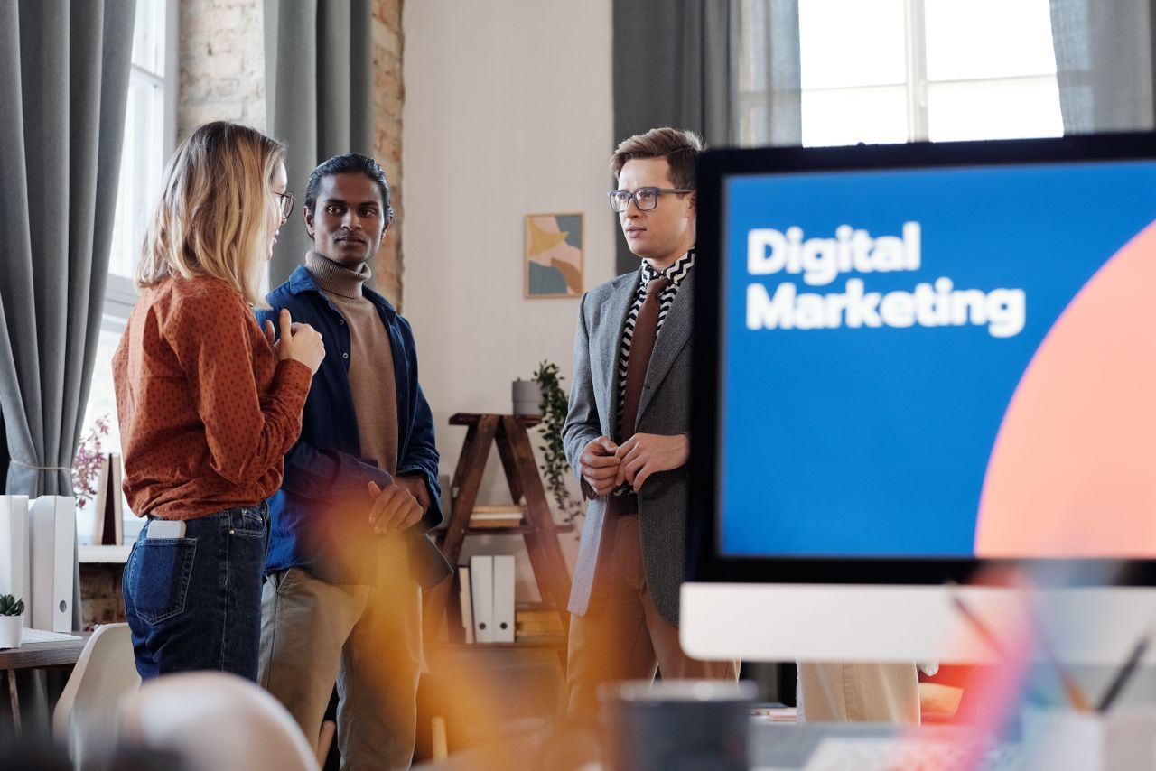 Home Group of colleagues discussing digital marketing strategies in an office setting.