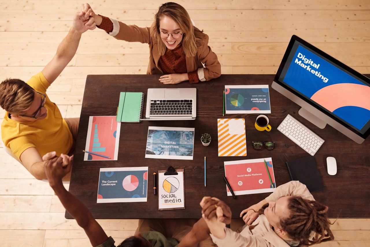 Home Colleagues celebrating success in a modern digital marketing office with teamwork and collaboration.